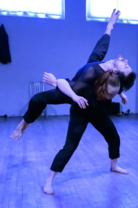 Two dancers perform a lift.